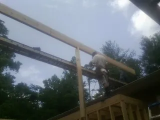 Carpenter setting a ridge beam over a new addition frame — Ice Dam Removal by Roofing Brothers in Rutland
